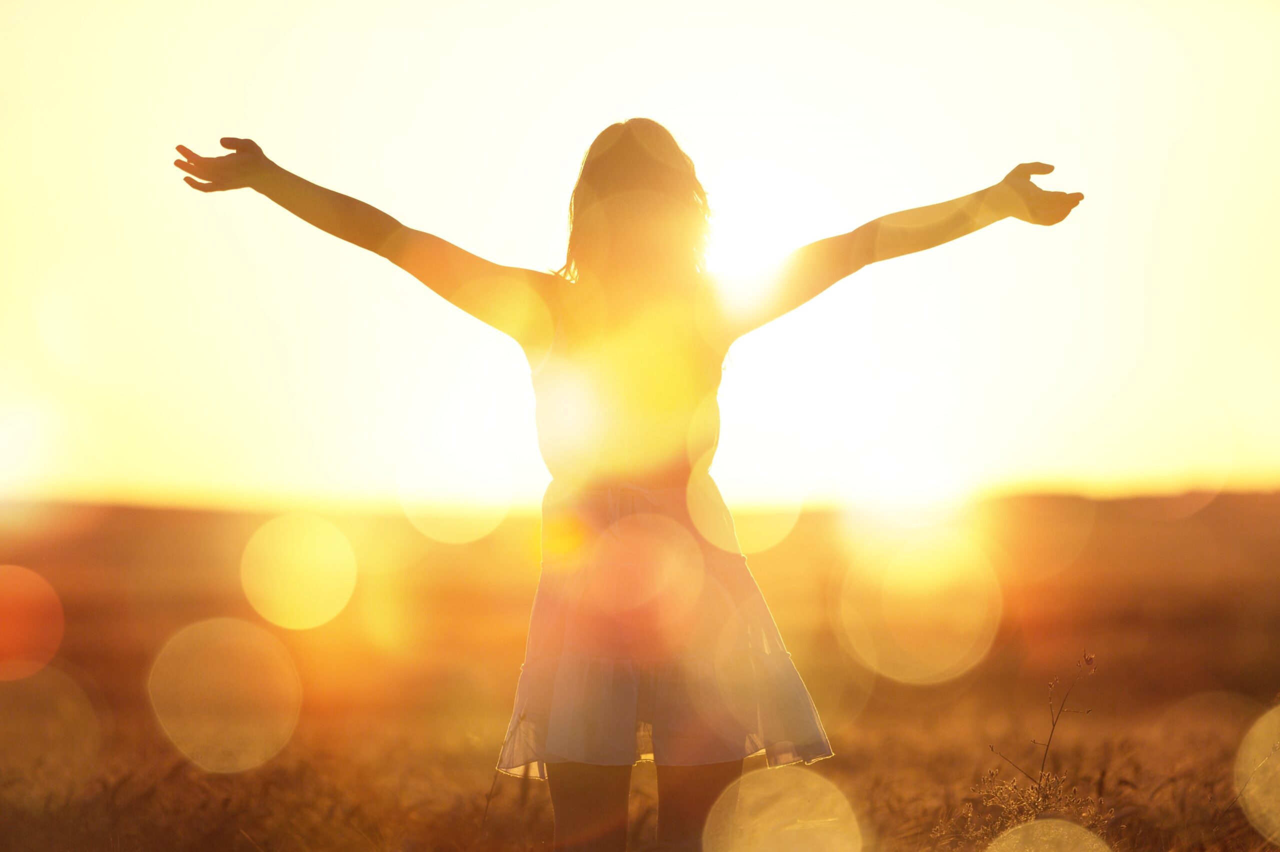 Young woman on field under sunset light AdobeStock 284215784 scaled